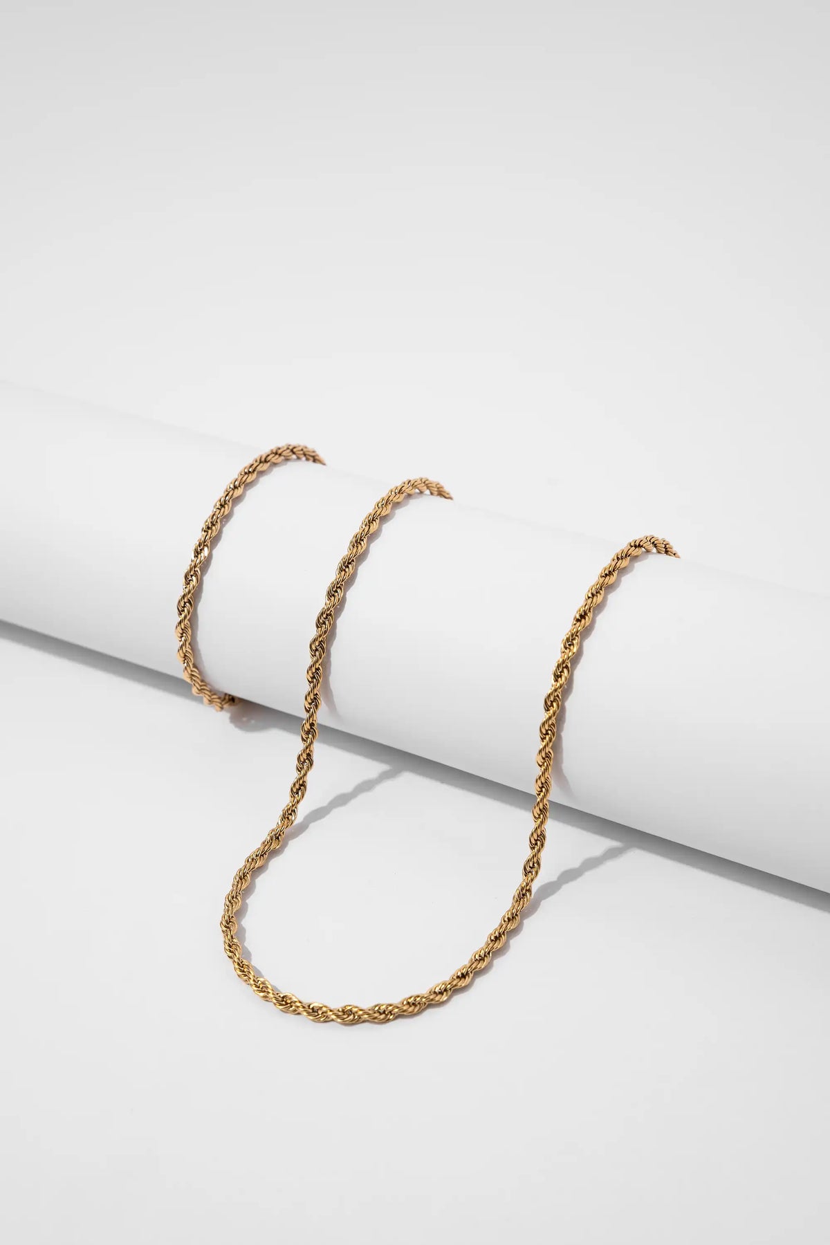 Pulsera Lazo Gold Impetu Men - cadena lazo sobre prop cilíndrico blanco vista lateral