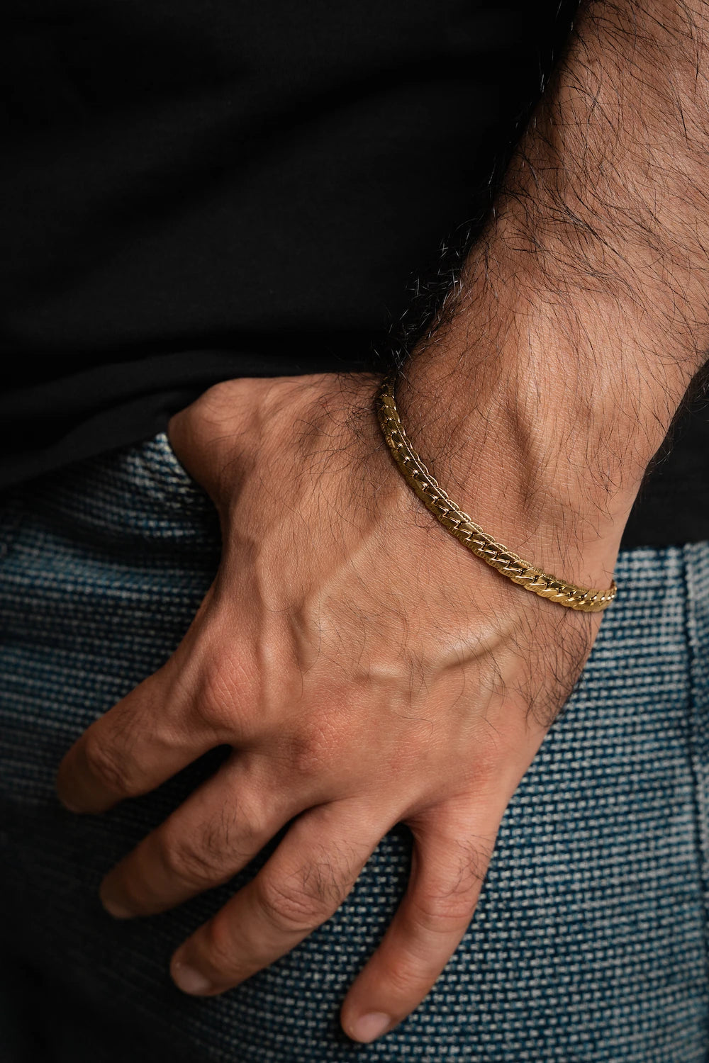 Pulsera Grabada Gold Impetu Men - modelo camiseta negra jeans detalle muñeca vista frontal