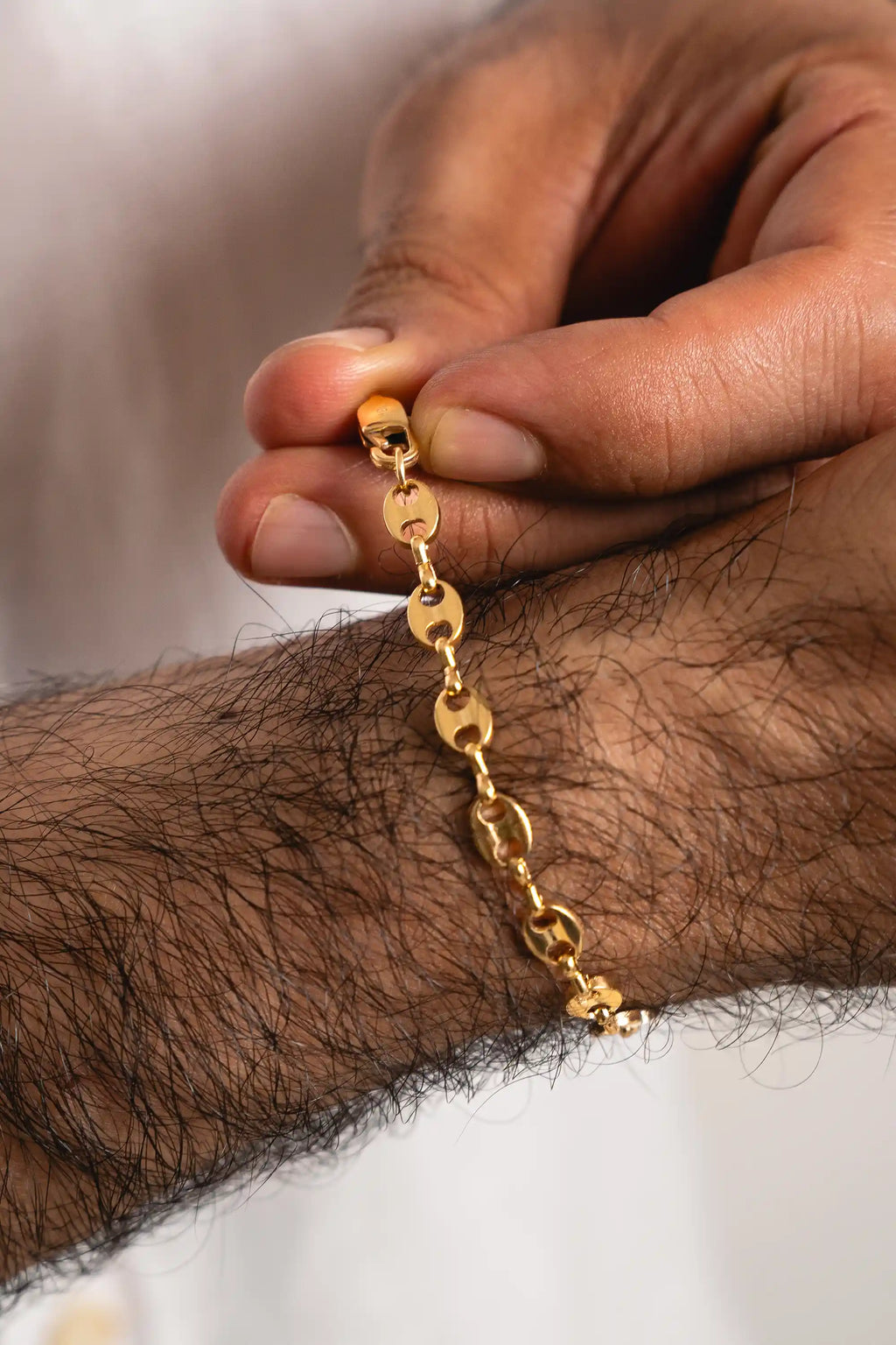 Pulsera Gucci Gold Impetu Men - pulsera sobre superficie tela blanca fondo blanco