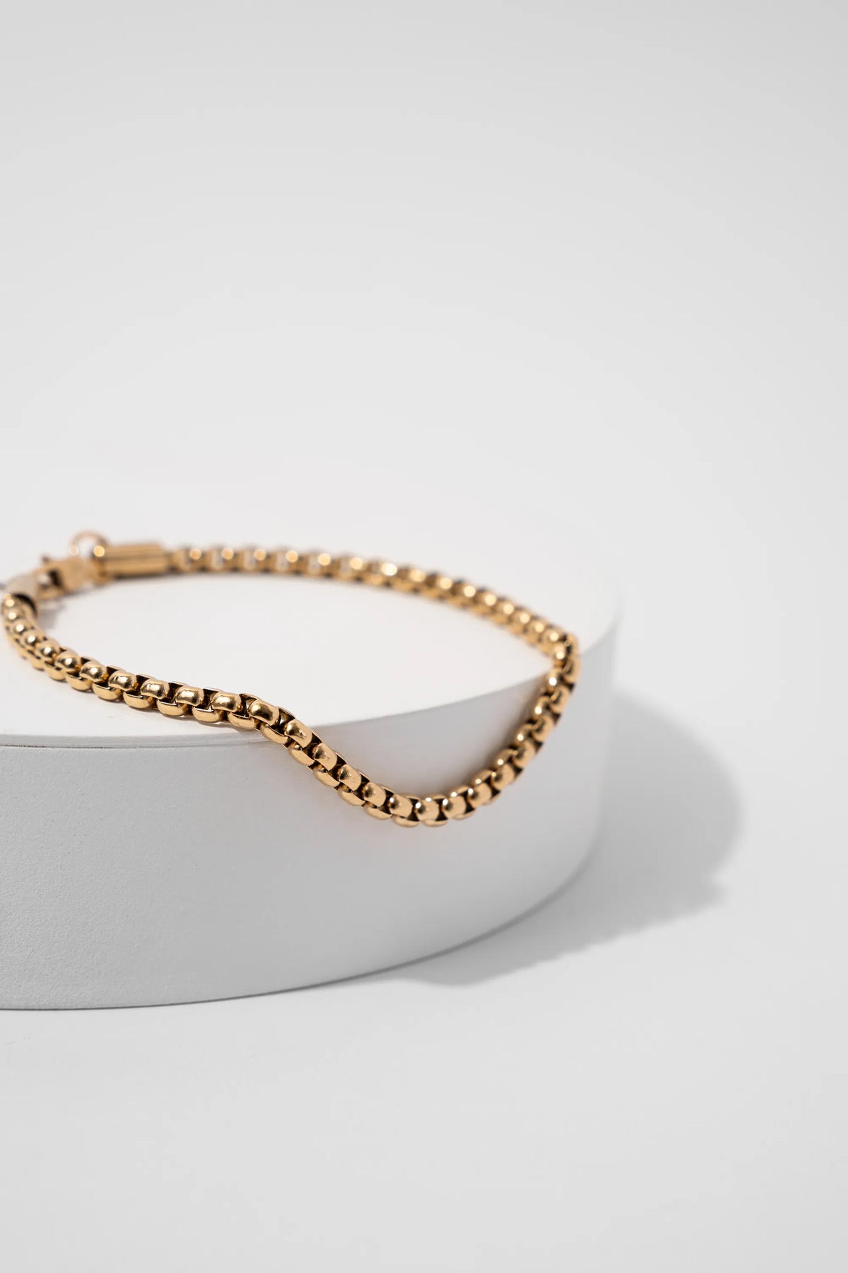 Pulsera Veneciana Gold Impetu Men - pulsera sobre prop cilíndrico blanco fondo blanco