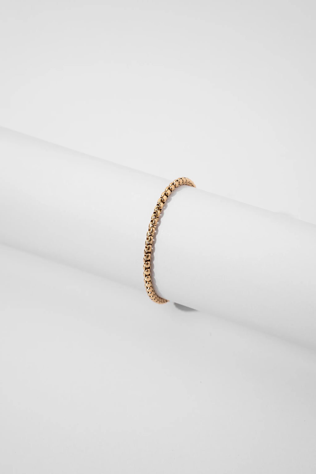 Pulsera Veneciana Gold Impetu Men - pulsera sobre prop redondo blanco fondo gris claro