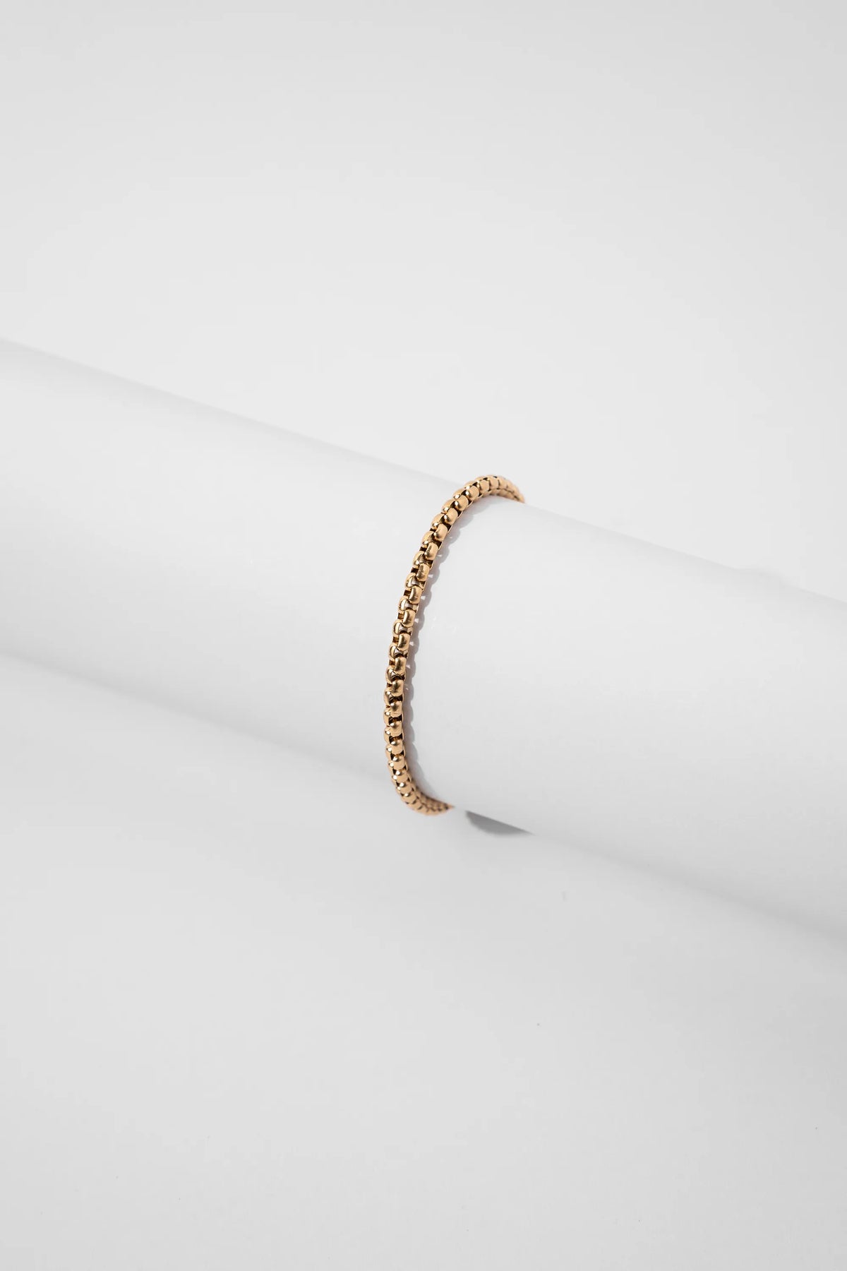 Pulsera Veneciana Gold Impetu Men - pulsera sobre prop redondo blanco fondo gris claro